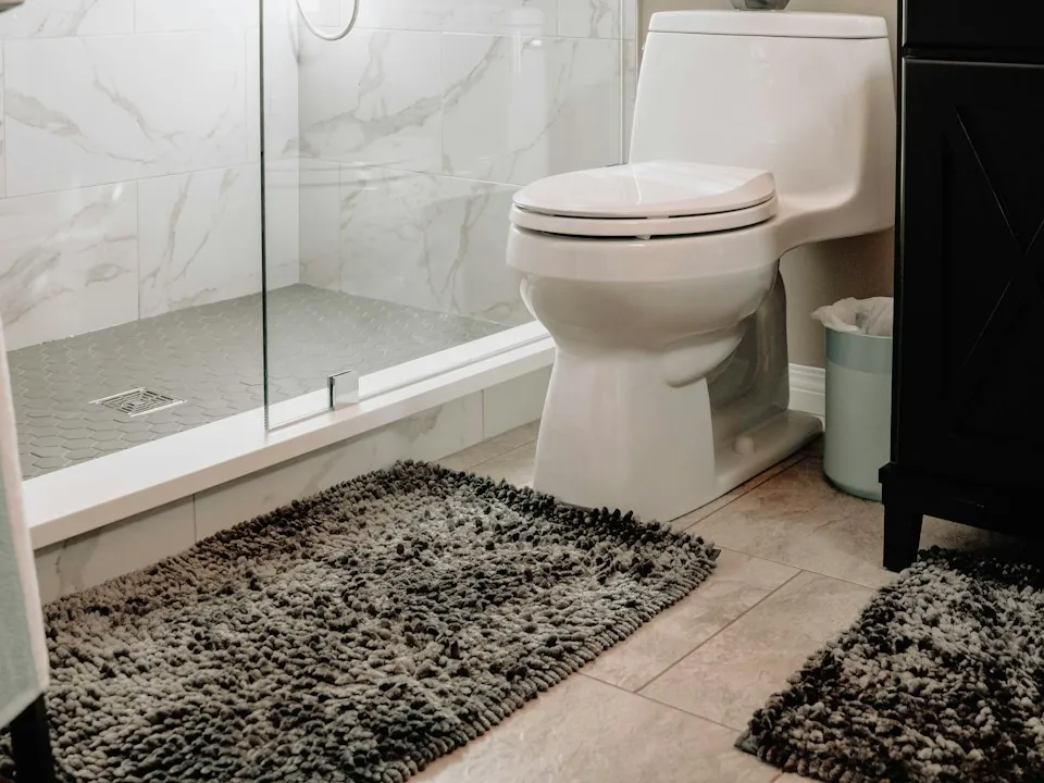 The same bathroom after renovation: walk-in shower and marble