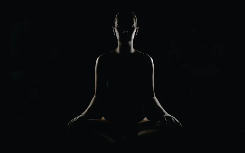 Silhouette meditating in the half-light